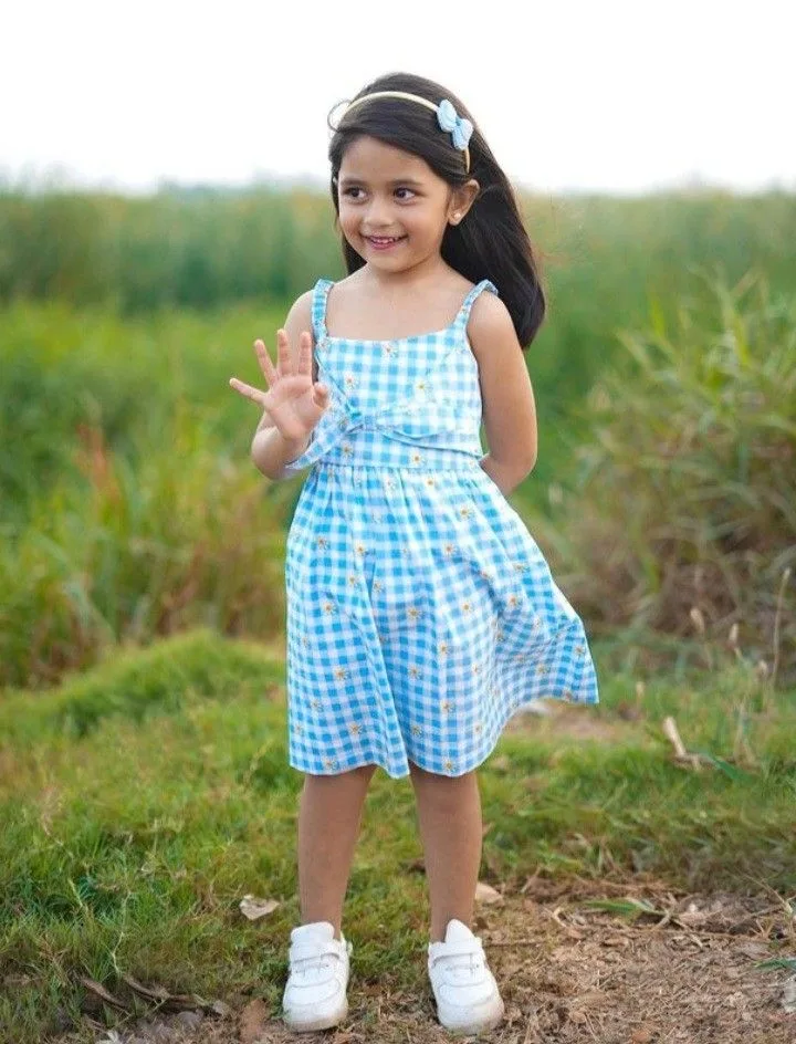 Candid Outdoor Portrait of a Smiling Little Girl in Gingham Dress