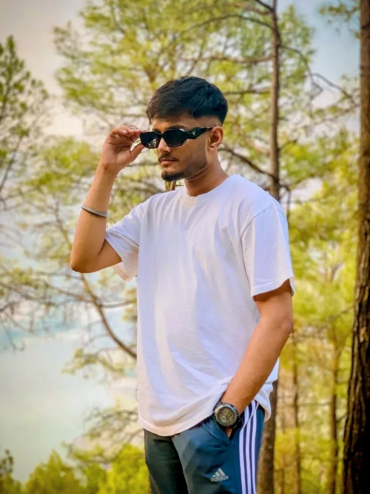 Outdoor Portrait of Young Man with Sunglasses in Pine Forest