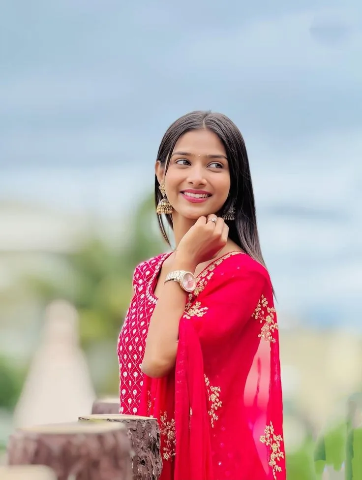 Candid Outdoor Portrait of Smiling Indian Woman in Crimson Suit