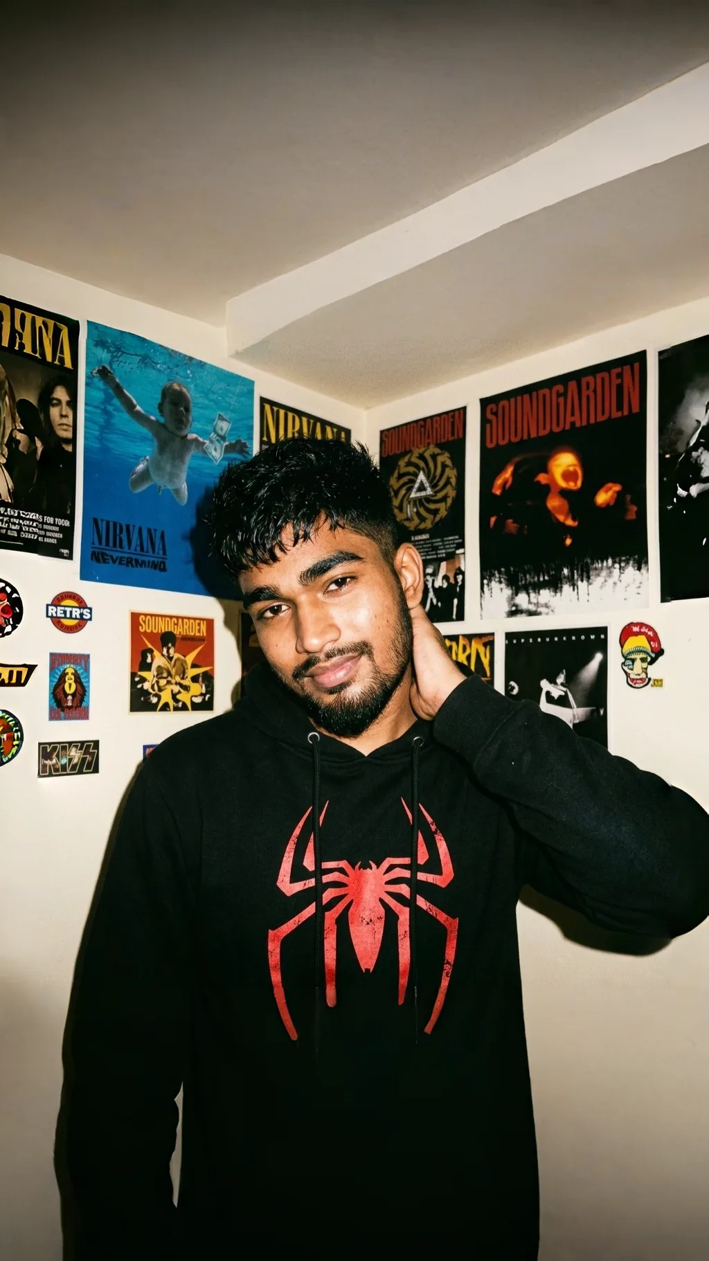 Candid Flash Portrait of Young Indian Man in Rock Poster Room