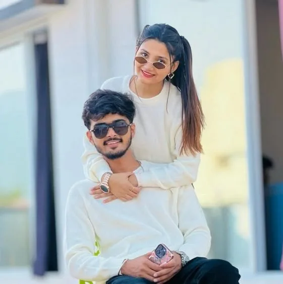 Candid Outdoor Portrait of Young Couple in Matching White Sweaters
