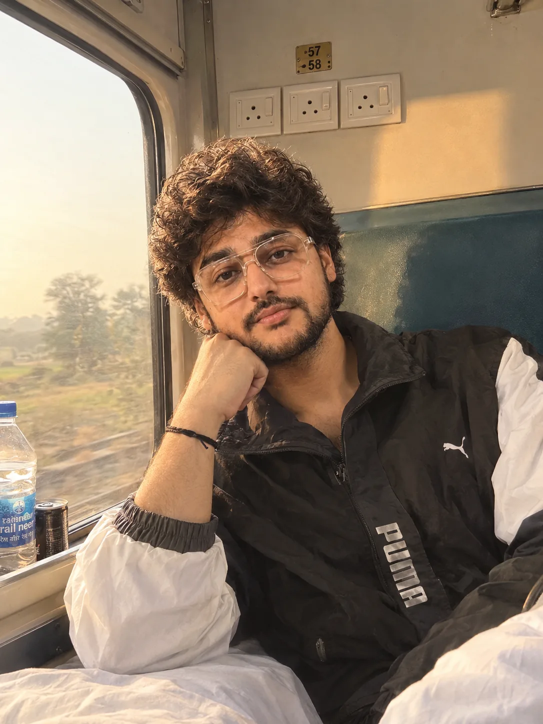 A young boy sitting in train window inside an Indian