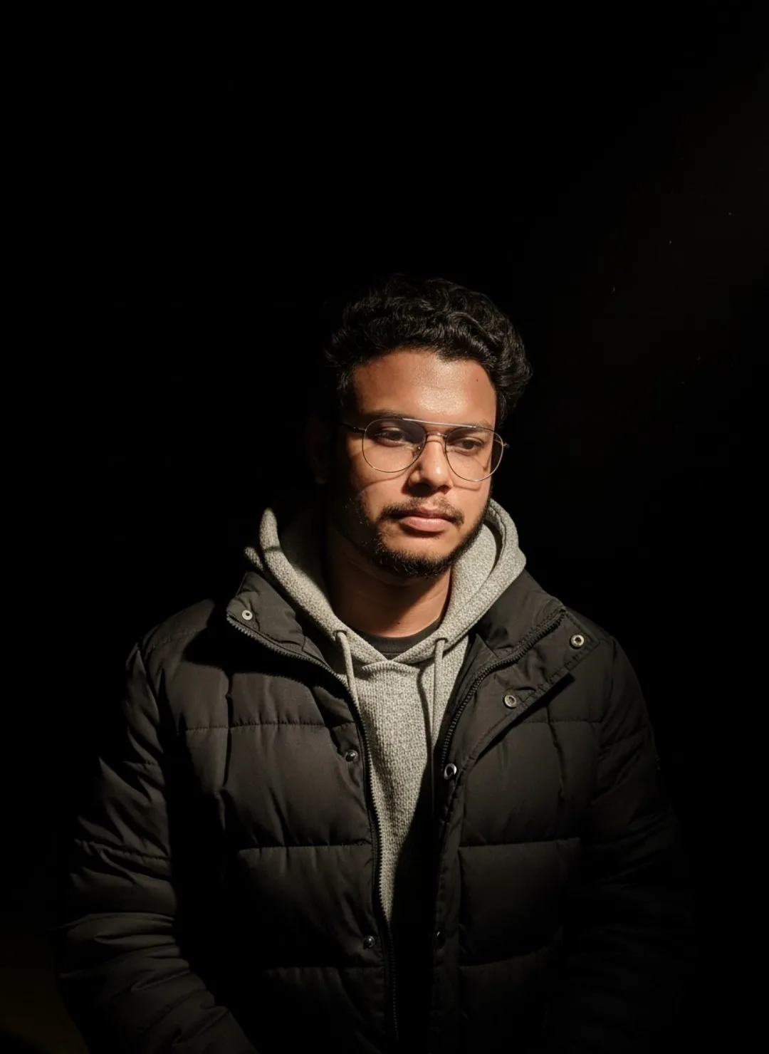 Dramatic Low-Key Portrait of Young Man in Black Puffer Jacket