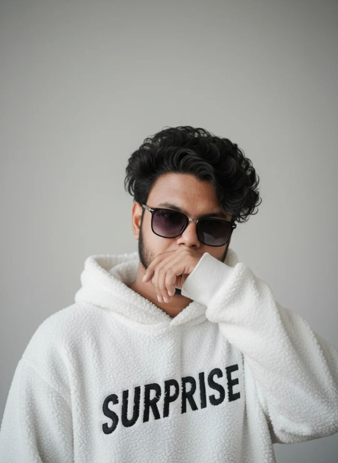 Title:** Cool Curly-Haired Guy in White “SURPRISE” Hoodie