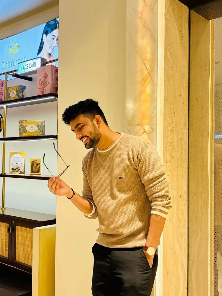 Candid Indoor Boutique Portrait of Young Man Holding Eyeglasses