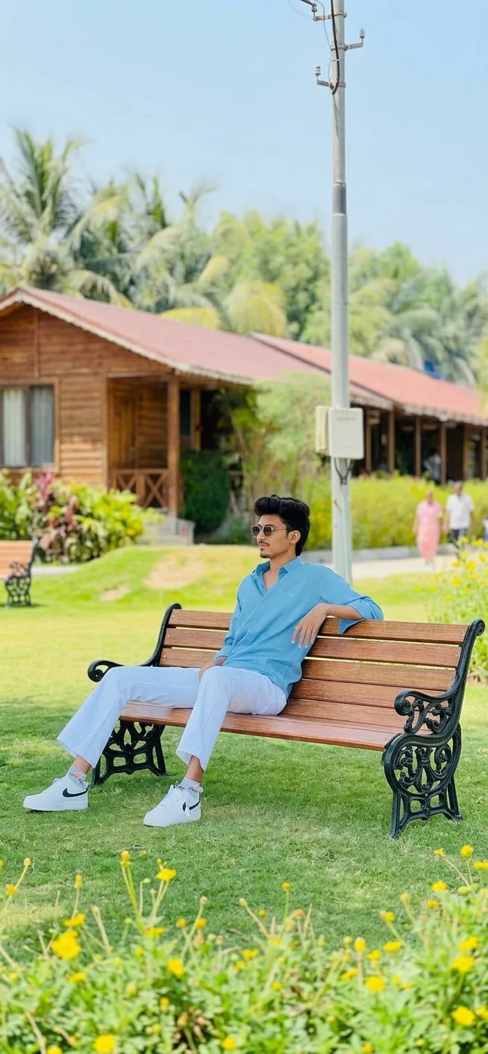 Candid Outdoor Portrait of Young Man Relaxing on Wooden Park Bench