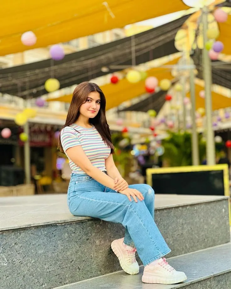 Young Woman Sitting Outdoors in Wide-Leg Jeans